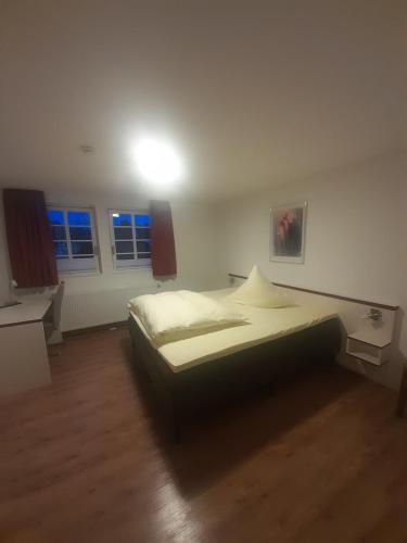 1 dormitorio con 1 cama y 2 ventanas en Hotel Adler, en Babenhausen