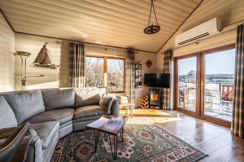 a living room with a couch and a tv at SAORSA CABIN in Lochinver