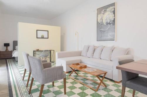 a living room with a white couch and chairs at Casa Monarcas - María Teresa (with AC) in Guadalajara