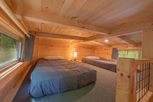 a bedroom with two beds in a log cabin at Papa Cabin Tiny Log Home Comfort In Rustic Bliss in Chattanooga