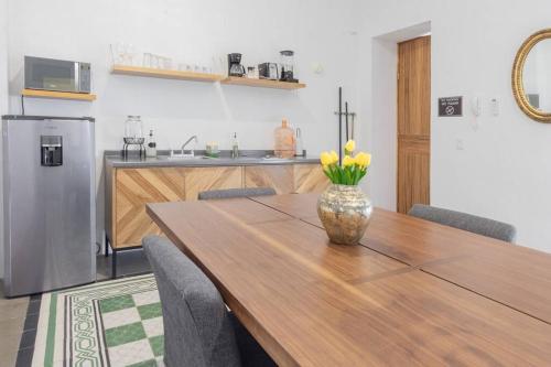 a dining room table with a vase of flowers on it at Casa Monarcas - María Teresa (with AC) in Guadalajara