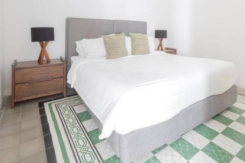 a bedroom with a large white bed and two lamps at Casa Monarcas - María Teresa (with AC) in Guadalajara