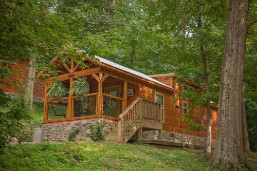 a log cabin in the woods with a large window at Nana Cabin Tiny Log Home Comfort In Rustic Bliss in Chattanooga