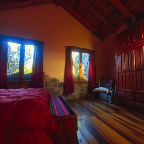 1 dormitorio con 2 ventanas, 1 cama y 1 silla en La Calandria en Los Hornillos
