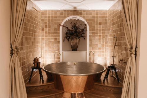 een bad in een badkamer met een vaas bij No 42 by GuestHouse, Margate in Margate