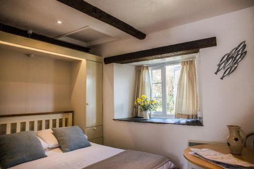 a bedroom with a bed and a window at The Tack Room in Hartland