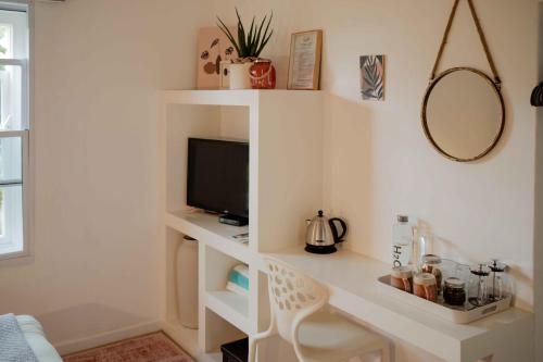 Zimmer mit einem Schreibtisch, einem TV und einem Spiegel in der Unterkunft La Sosta in Swellendam