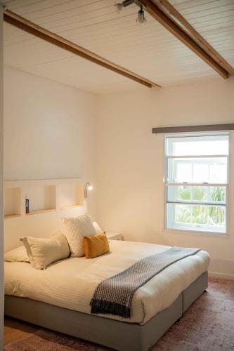 a bedroom with a large bed with a window at La Sosta in Swellendam