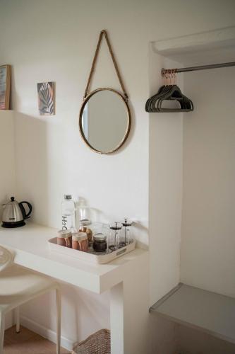 a white counter with a mirror on a wall at La Sosta in Swellendam