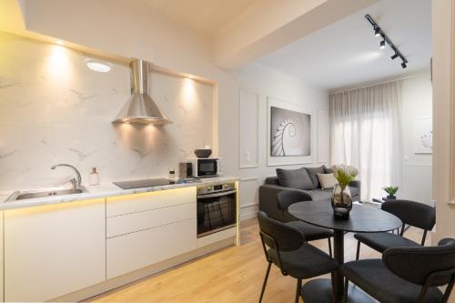 een keuken en een woonkamer met een tafel bij Artsy Loft in the heart of Koukaki in Athene