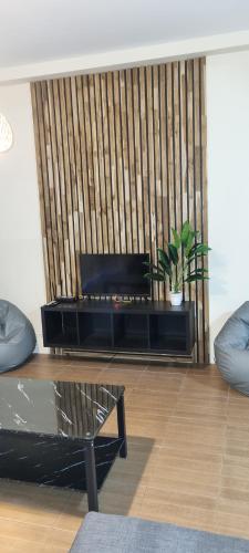 un soggiorno con un centro di intrattenimento nero con una pianta di Khao Jaï Rooms a Thong Sala