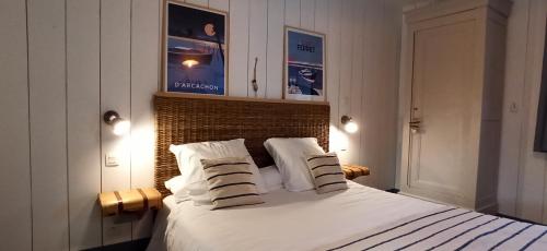 une chambre avec un lit blanc avec deux oreillers dans l'établissement Gîte Timellen - piscine privative chauffée- 300m parcours de Golf Cassy Lanton, à Lanton