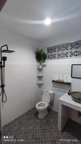 bagno con servizi igienici e pianta sul muro di Khao Jaï Rooms a Thong Sala