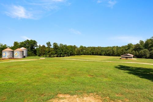a large grassy field with two buildings in the distance at Three Silos Farm -Chatt Hills (NEW & Pet Friendly) in Chattahoochee Hills