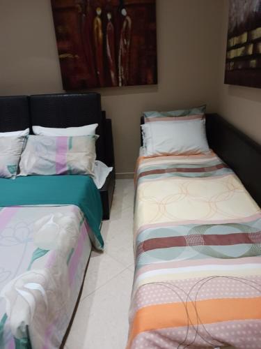 two beds sitting next to each other in a room at Green House in Néa Péramos