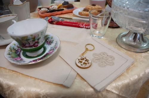 a table with a tea cup and a key on it at Fly bed and breakfast in Ancarano