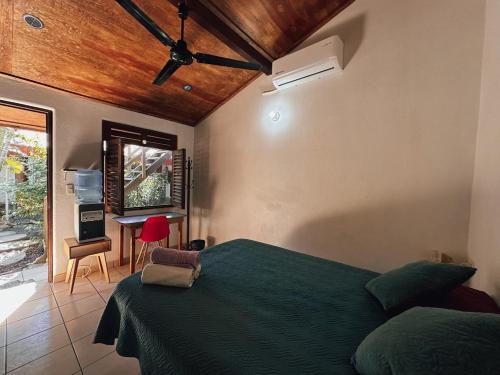 - une chambre avec un lit vert et un bureau dans l'établissement Pacific Buddha, à Brisas de Zicatela