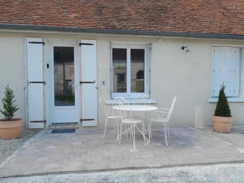 een tafel en stoelen voor een huis bij Maison de campagne 4 personnes proche de Loches in Chambourg-sur-Indre