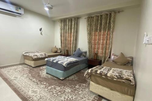 a bedroom with two beds and a rug at Shaqaf shalet 