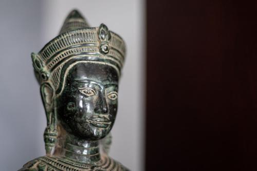 a bronze vase with a face on it at Hotel Vellita Siem reap in Siem Reap