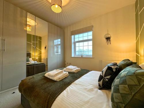 ein Schlafzimmer mit einem Bett mit zwei Handtüchern darauf in der Unterkunft Stylish 1 Bedroom Apartment with Sofa Bed - Opposite Racecourse, Near City Centre and Hospital in Doncaster