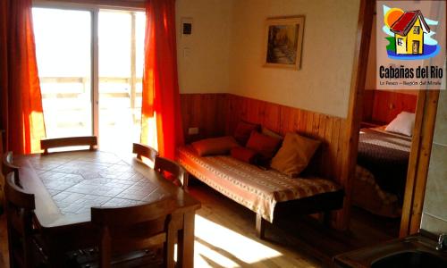 - un salon avec un canapé et une fenêtre dans l'établissement Cabañas del Rio - La Pesca - Region del Maule, à Iloca