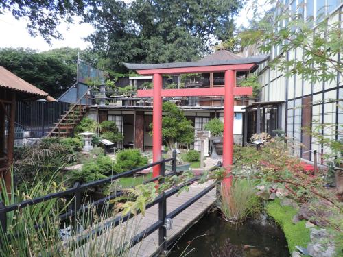 um jardim com uma estrutura vermelha ao lado de um lago em Zen Museu do Bonsai em Sintra