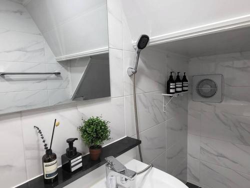 a white bathroom with a shower and a sink at Seoul National University Apartment in Seoul