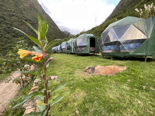 una fila de tiendas estacionadas junto a una montaña en Sky Lodge Domes Chaullay, en Colcapampa