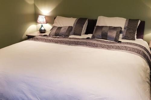 a bedroom with a large white bed with a lamp at Central House in Shillelagh