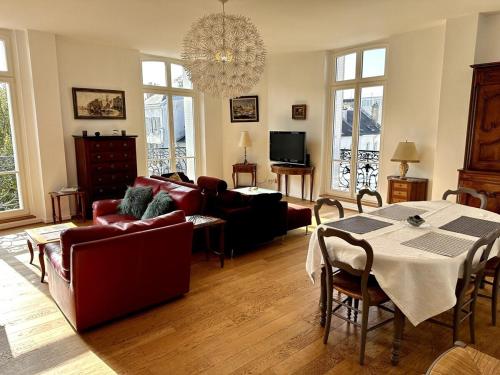 un salon avec un canapé et une table dans l'établissement Le Grand Rockefeller Parvis de la Cathédrale de Reims, à Reims