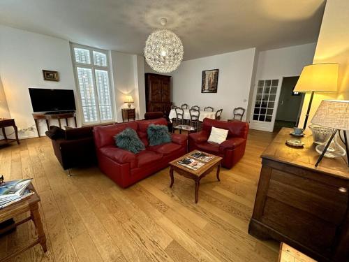un salon avec des canapés rouges et une table dans l'établissement Le Grand Rockefeller Parvis de la Cathédrale de Reims, à Reims