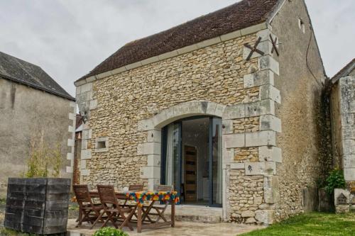 a stone building with two chairs and a table at L'atelier in Chambourg-sur-Indre