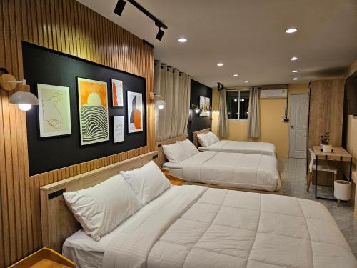 ハジャイにあるMy Home Pool Villa Hatyaiのベッド2台とデスクが備わるホテルルームです。