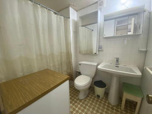 a white bathroom with a toilet and a sink at Departamento excelente ubicación frente a playa in Viña del Mar