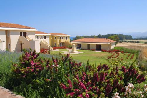 a row of houses with flowers in a yard at Akamanthea Holiday Village in Polis Chrysochous