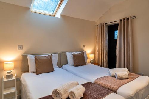Finest Retreats - The Lodge at The Cridford Inn في Trusham: سريرين يجلسون بجانب بعض في غرفة النوم
