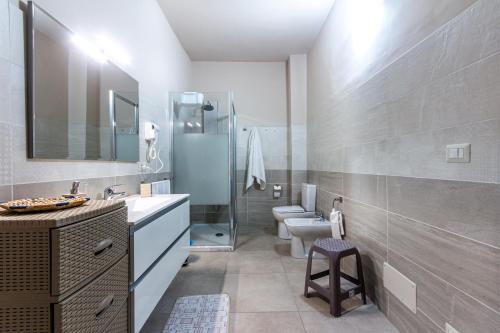 a bathroom with a sink and a toilet and a shower at Etna Sunshine Apartments in Linguaglossa