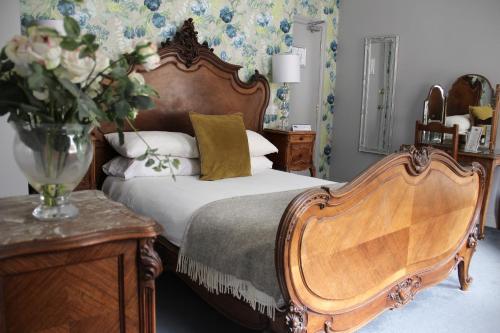 a bedroom with a bed and a vase of flowers at Blue Boar Hotel in Maldon