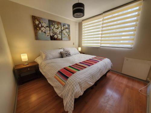 ein Schlafzimmer mit einem Bett und einem Fenster mit zwei Lampen in der Unterkunft Encantador Metro Central in Santiago