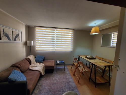 ein Wohnzimmer mit einem Sofa und einem Tisch in der Unterkunft Encantador Metro Central in Santiago