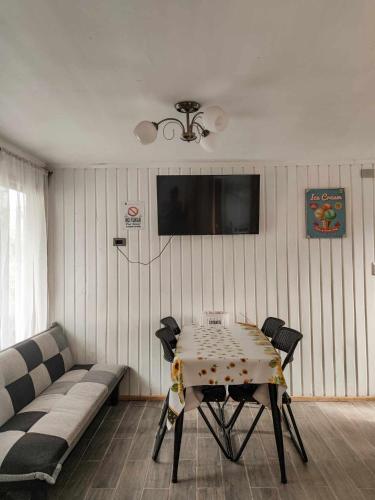 a living room with a table and a couch at Cabañas El Trébol, a 5 minutos del aeropuerto in Puerto Montt