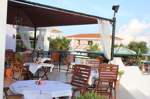 a patio with tables and chairs and an umbrella at Akamanthea Holiday Village in Polis Chrysochous