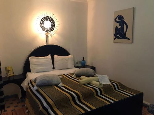 - une chambre avec un lit avec deux animaux rembourrés dans l'établissement Hôtel Riad Gnaoua, à Essaouira