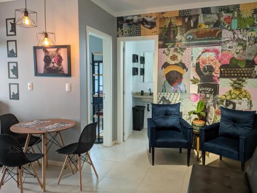 una sala da pranzo con tavolo, sedie e parete coperta di Cantinho Estilo a Santa Maria