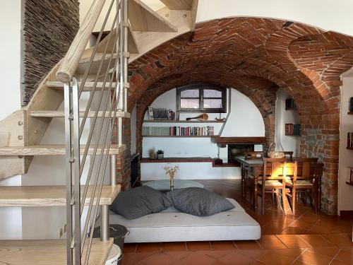a bedroom with a loft bed and a spiral staircase at Maison Mabette in Farigliano