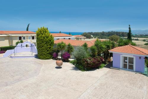 a large courtyard with a house and some plants at Akamanthea Holiday Village in Polis Chrysochous