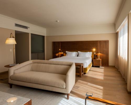 a hotel room with a bed and a couch at Costanero Hotel Montevideo - MGallery Collection in Montevideo