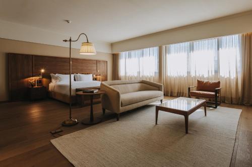 a large hotel room with a bed and a couch at Costanero Hotel Montevideo - MGallery Collection in Montevideo