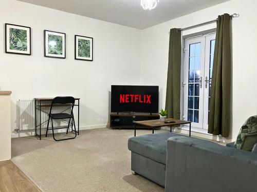 ein Wohnzimmer mit einem TV und einem Sofa in der Unterkunft Stylish 1 Bedroom Apartment with Sofa Bed - Opposite Racecourse, Near City Centre and Hospital in Doncaster
